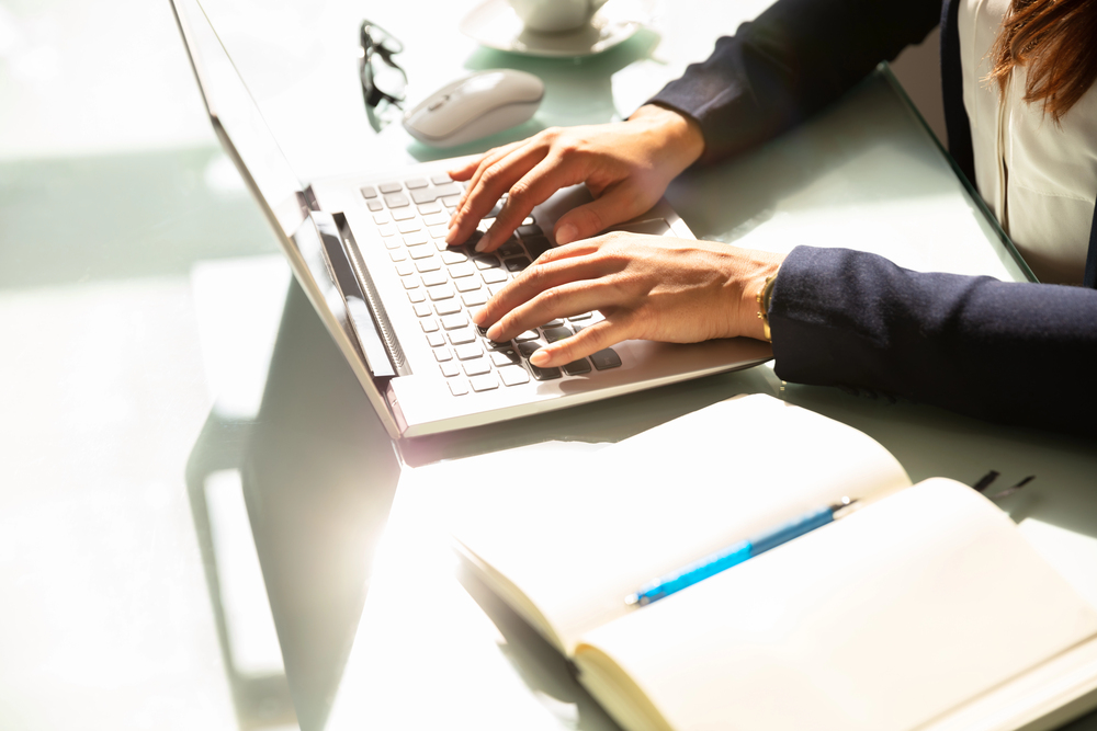 Content Writer Using Laptop with a Blank Notepad